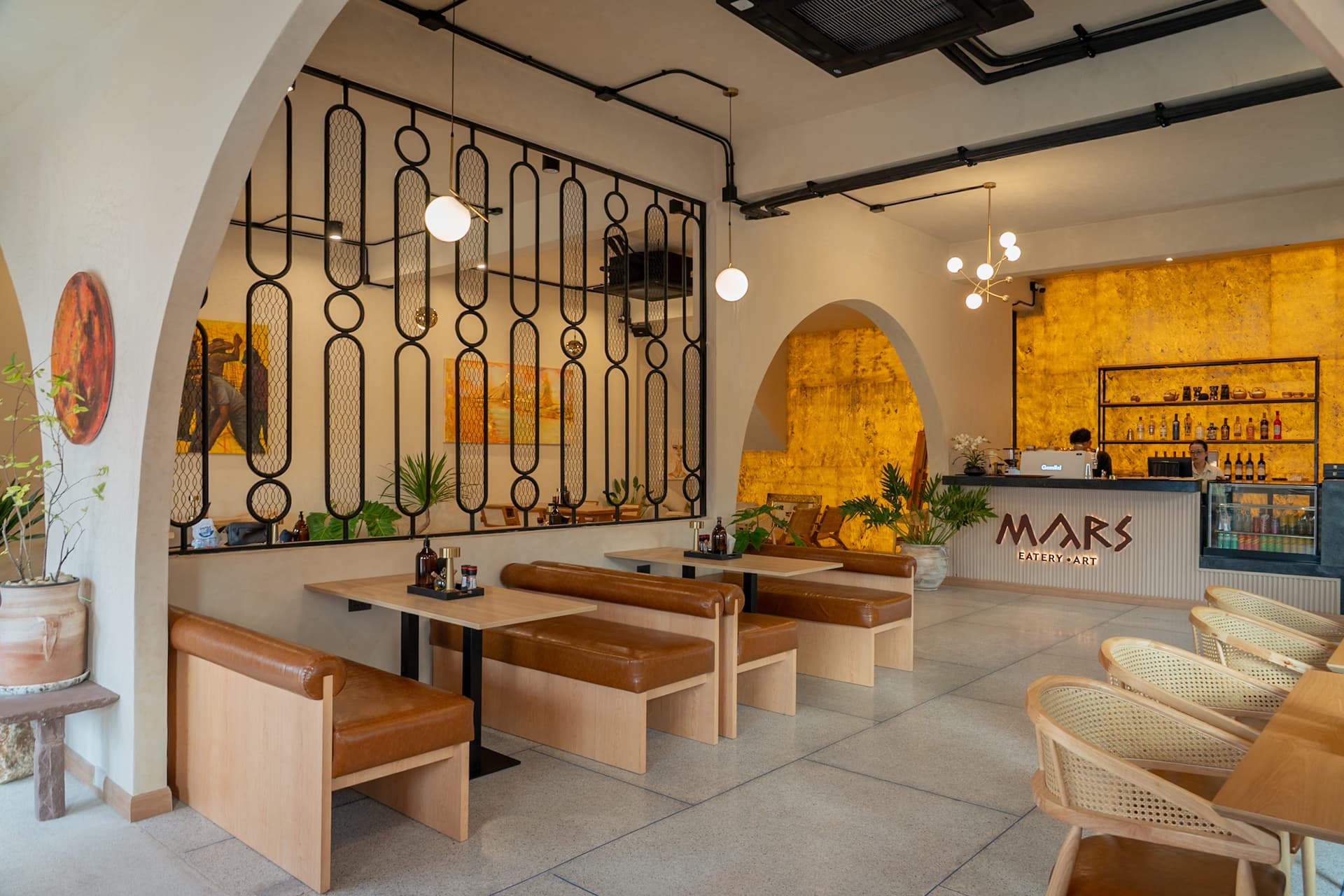 Inside MARS — cream plaster, arches and a golden bar wall